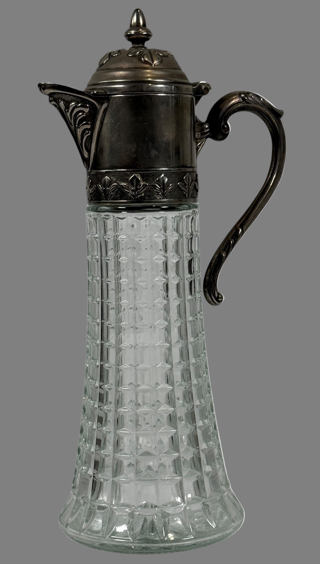 Decorative glass carafe with metal lid and handle on a white background