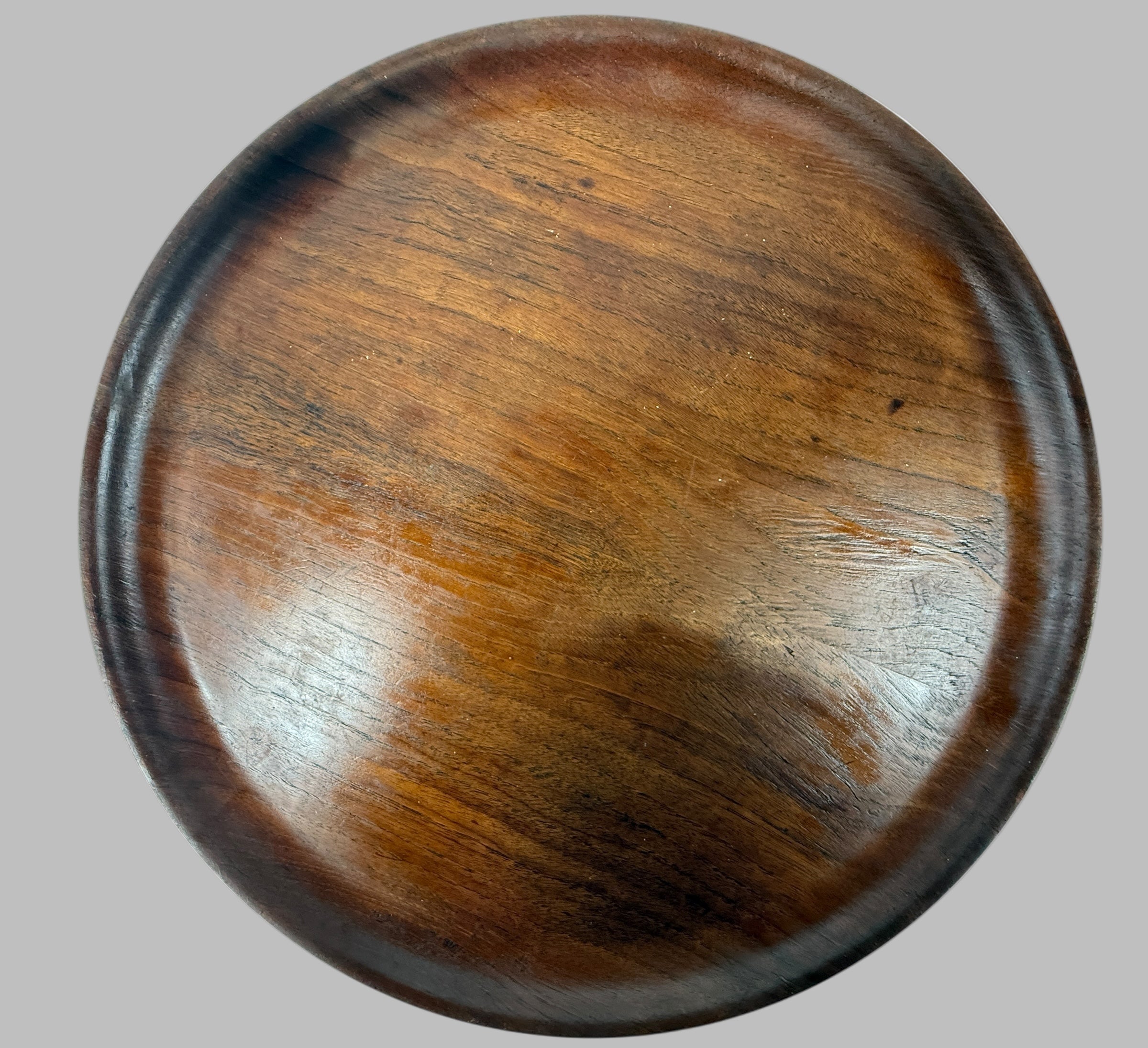 Round wooden coaster with a dark brown finish on a white background