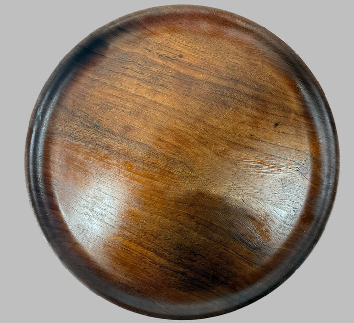 Round wooden coaster with a dark brown finish on a white background