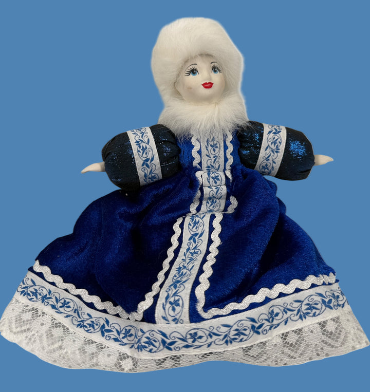 Doll in a blue dress with white fur hat on a white background