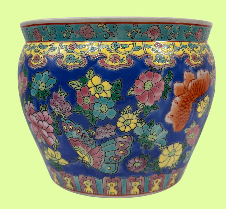 Decorative ceramic pot with floral and butterfly patterns on a blue background
