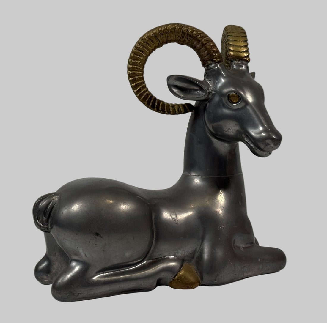 Decorative figurine of a ram with gold horns on a white background