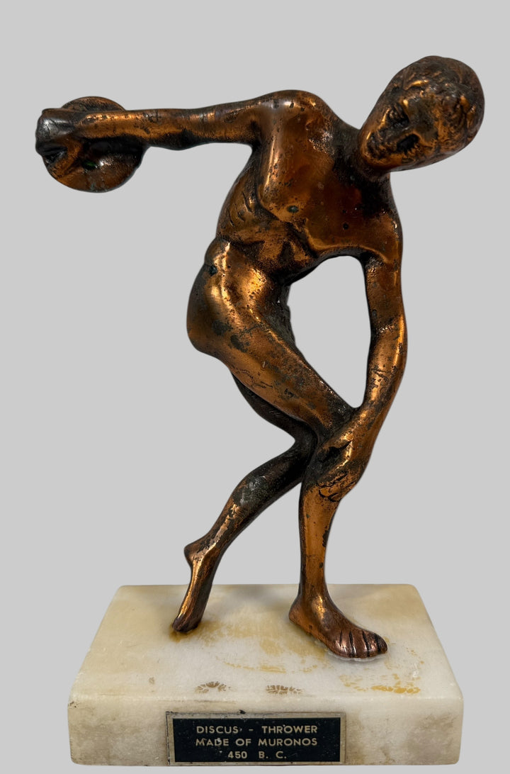 Bronze statue of a discus thrower on a marble base with a white background
