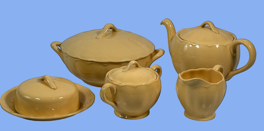 Set of ceramic tea pots and dishes on a black background