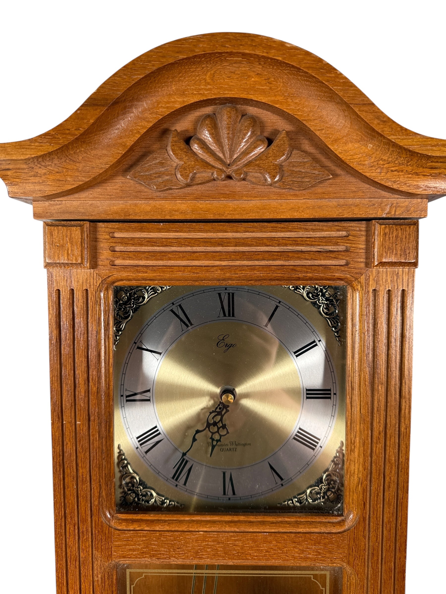 Wooden clock with decorative top on a white background