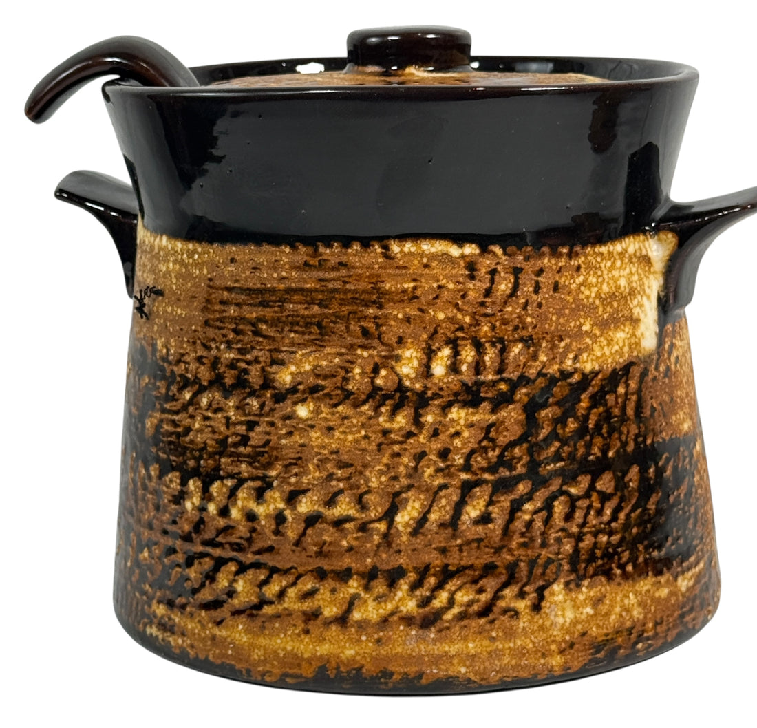 Ceramic pot with black and gold glaze on a white background