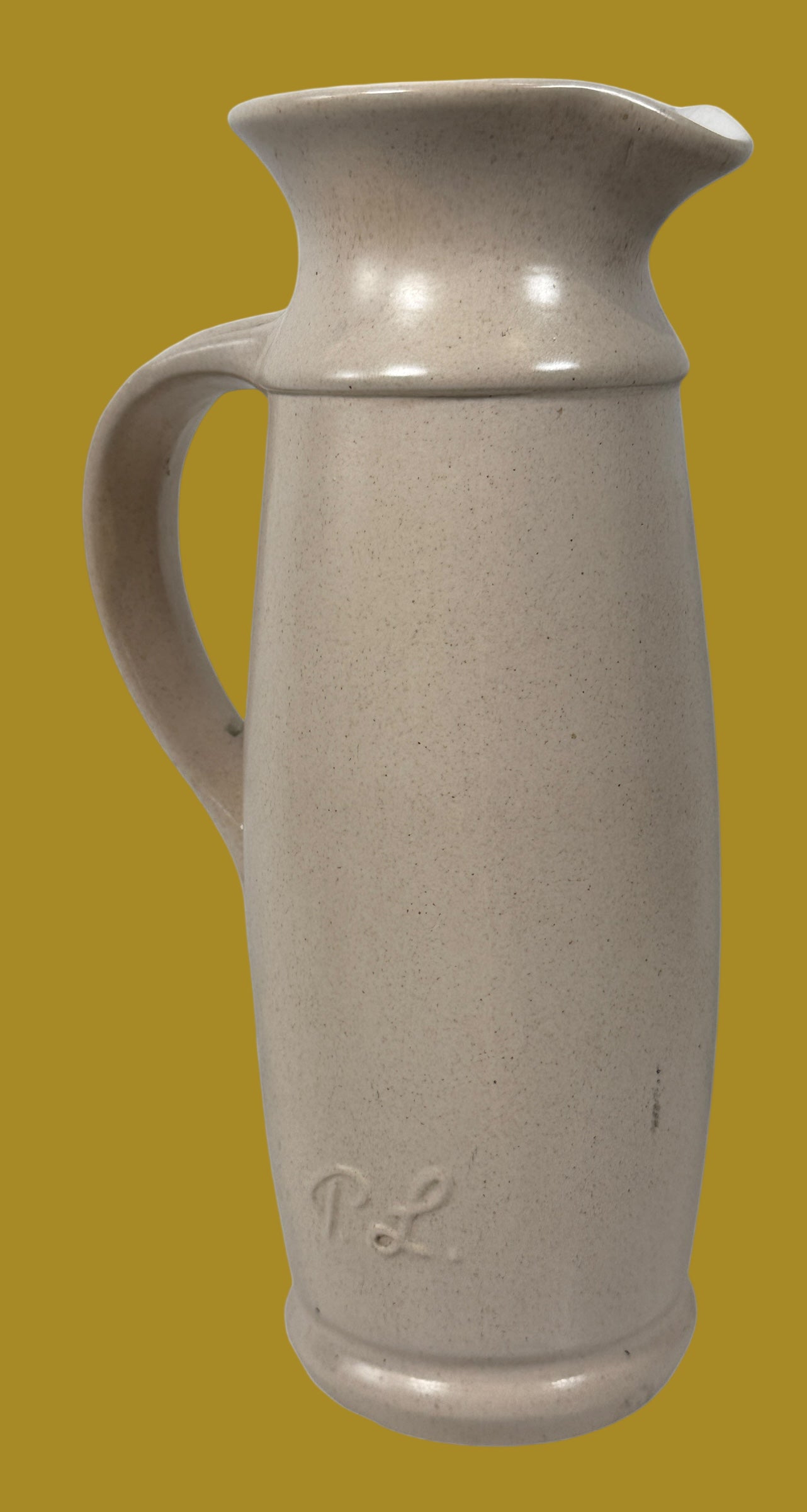 Beige ceramic pitcher with a handle on a white background