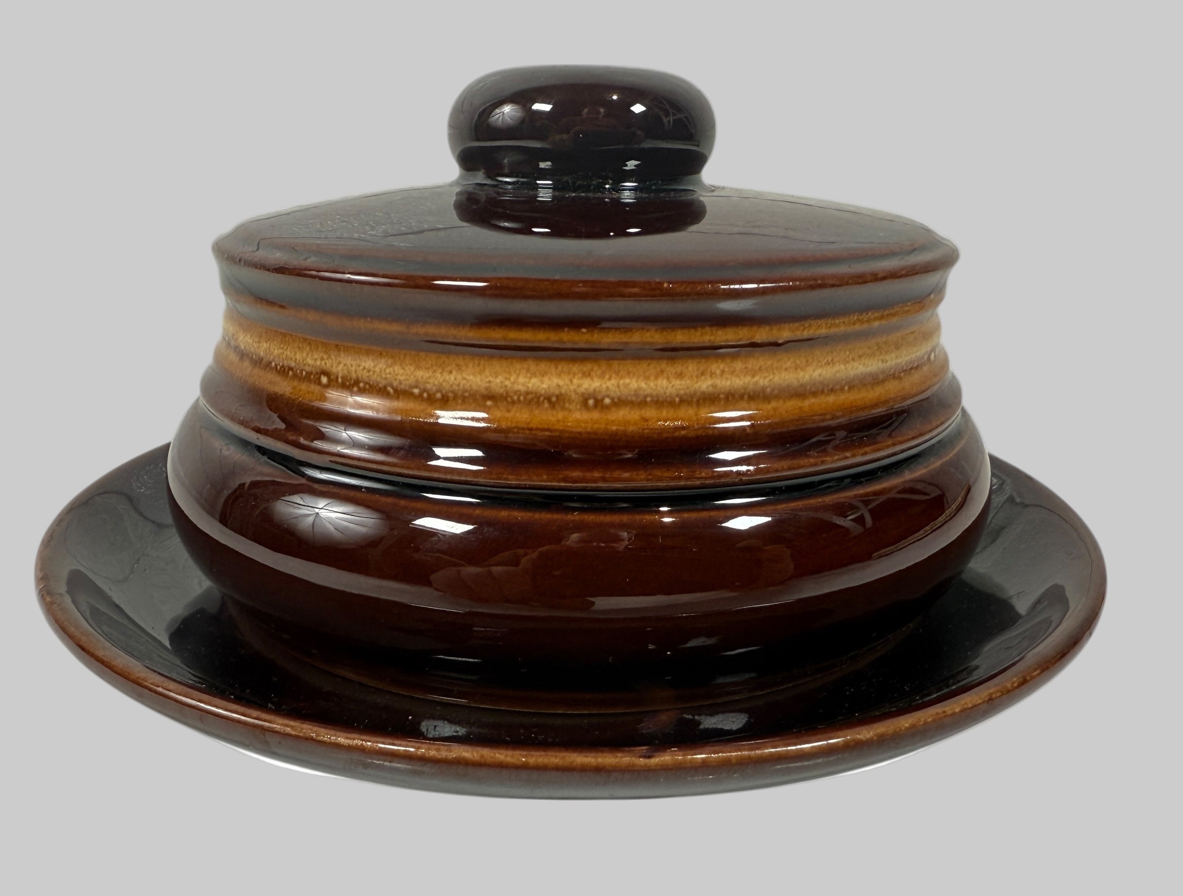 Brown ceramic dish with lid on a white background
