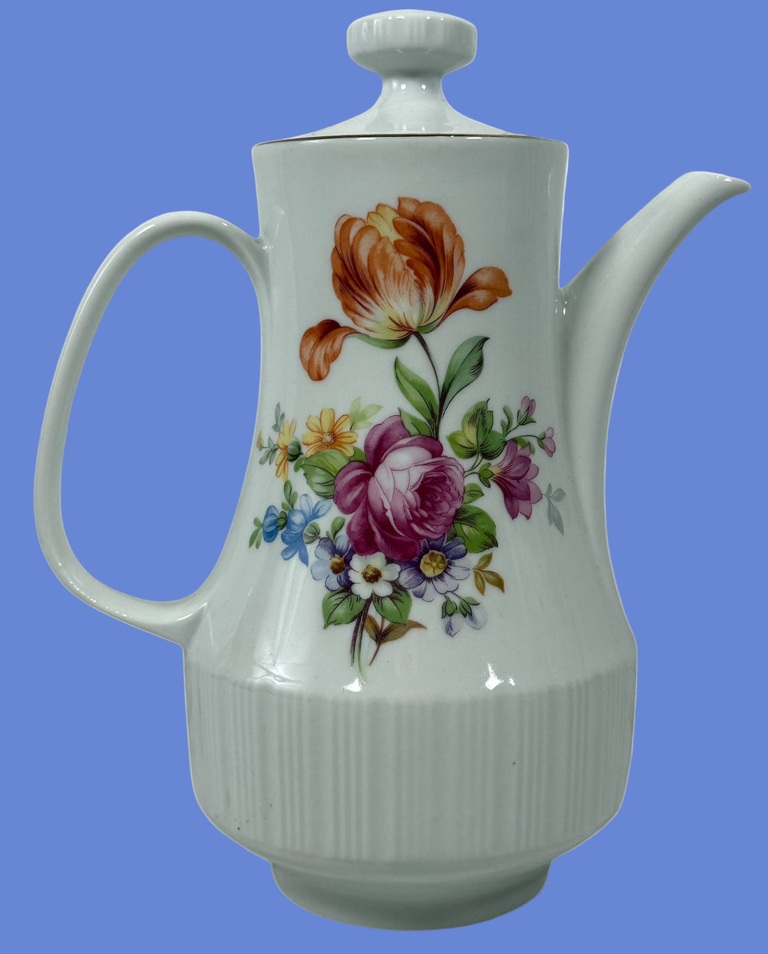 White ceramic teapot with floral designs on a white background