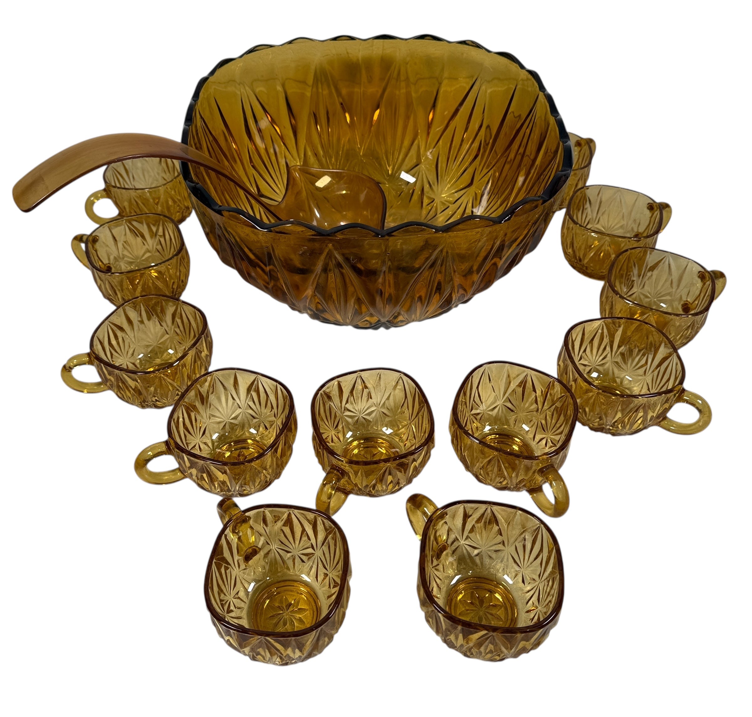 Vintage mid-century amber glass punch bowl set with cups and ladle. Classic starburst pattern, complete set, perfect for retro entertaining.