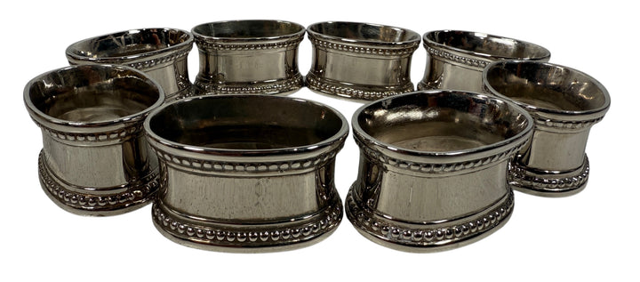 Set of 8 classic silverplate napkin rings with beaded edges. Unmonogrammed, polished, and in very good condition. Timeless tableware.