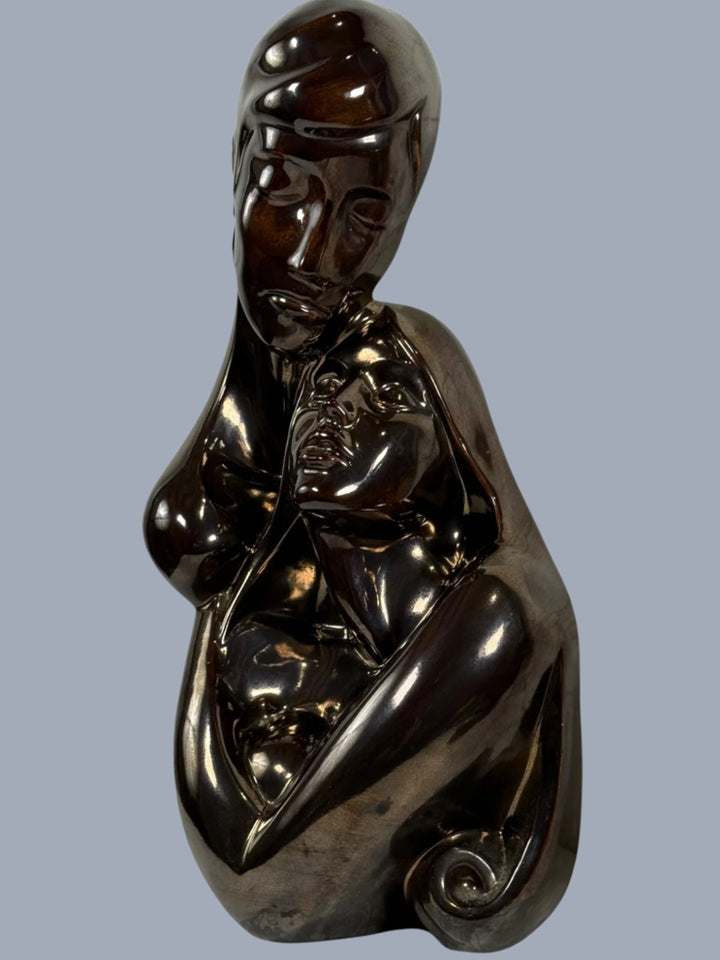 Bronze sculpture of a nude figure on a white background
