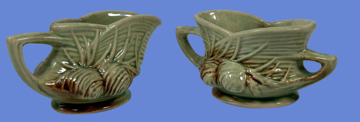 Two green ceramic leaf-shaped dishes on a white background