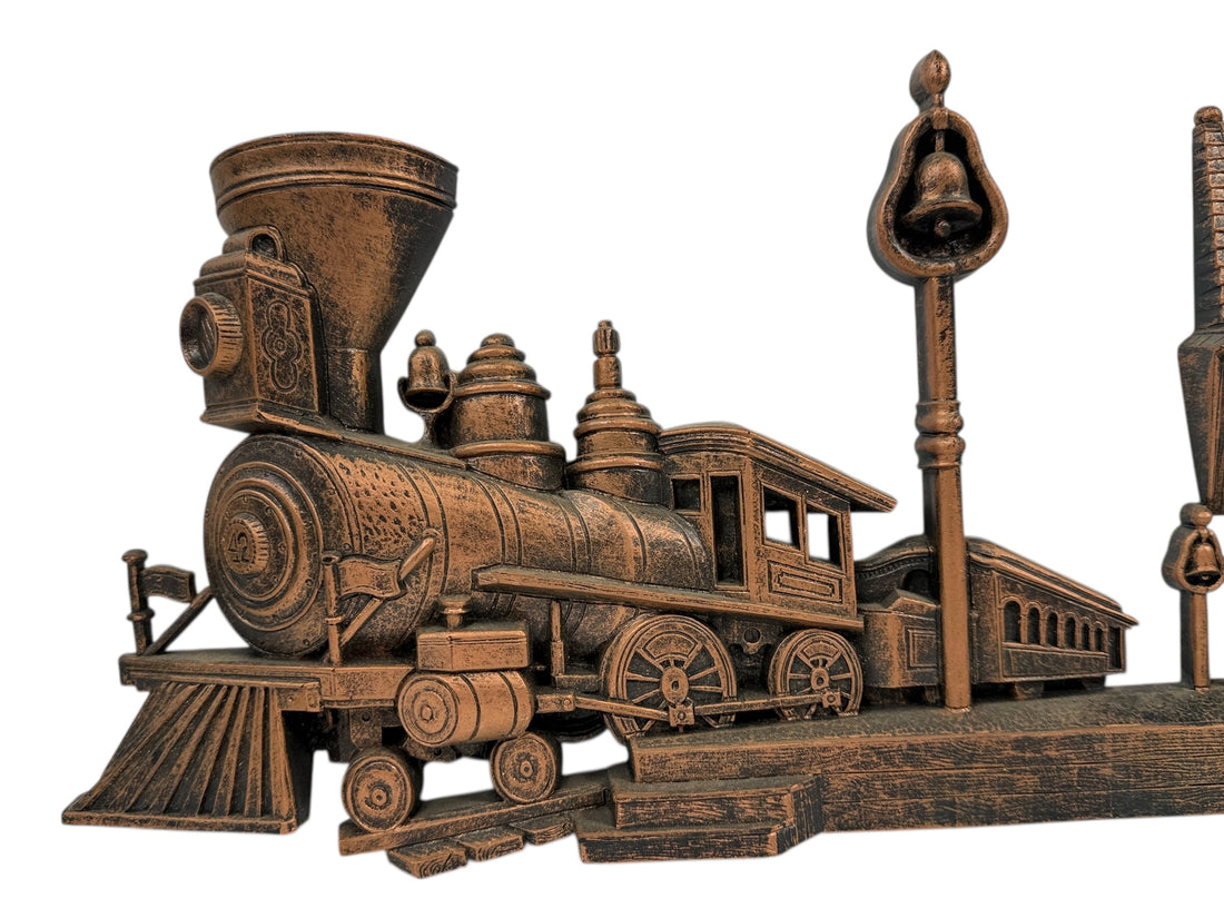 Bronze-colored model of a steam locomotive on a white background