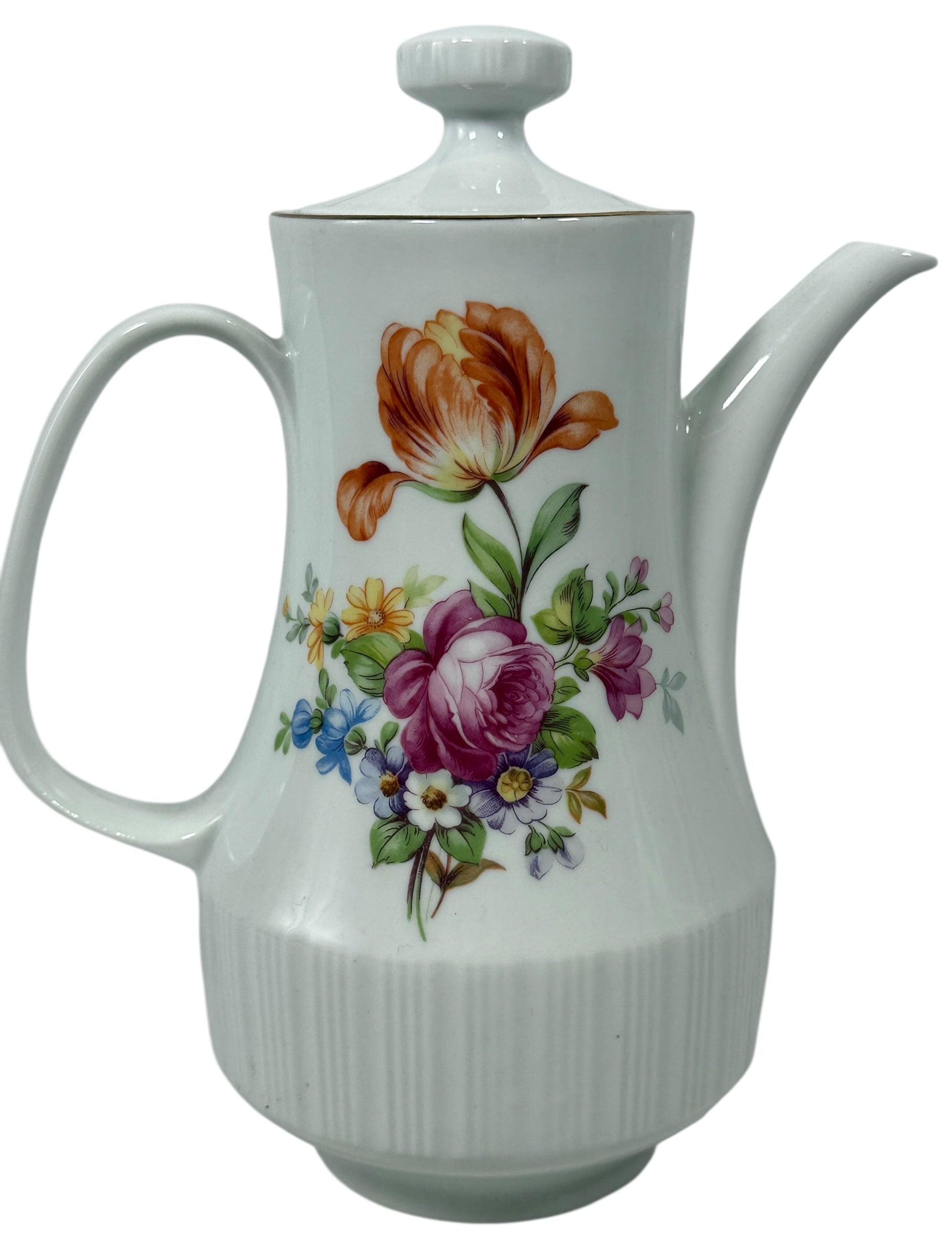 White ceramic teapot with floral design on a white background