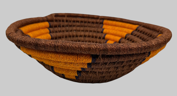 Woven basket with brown and orange pattern on a white background