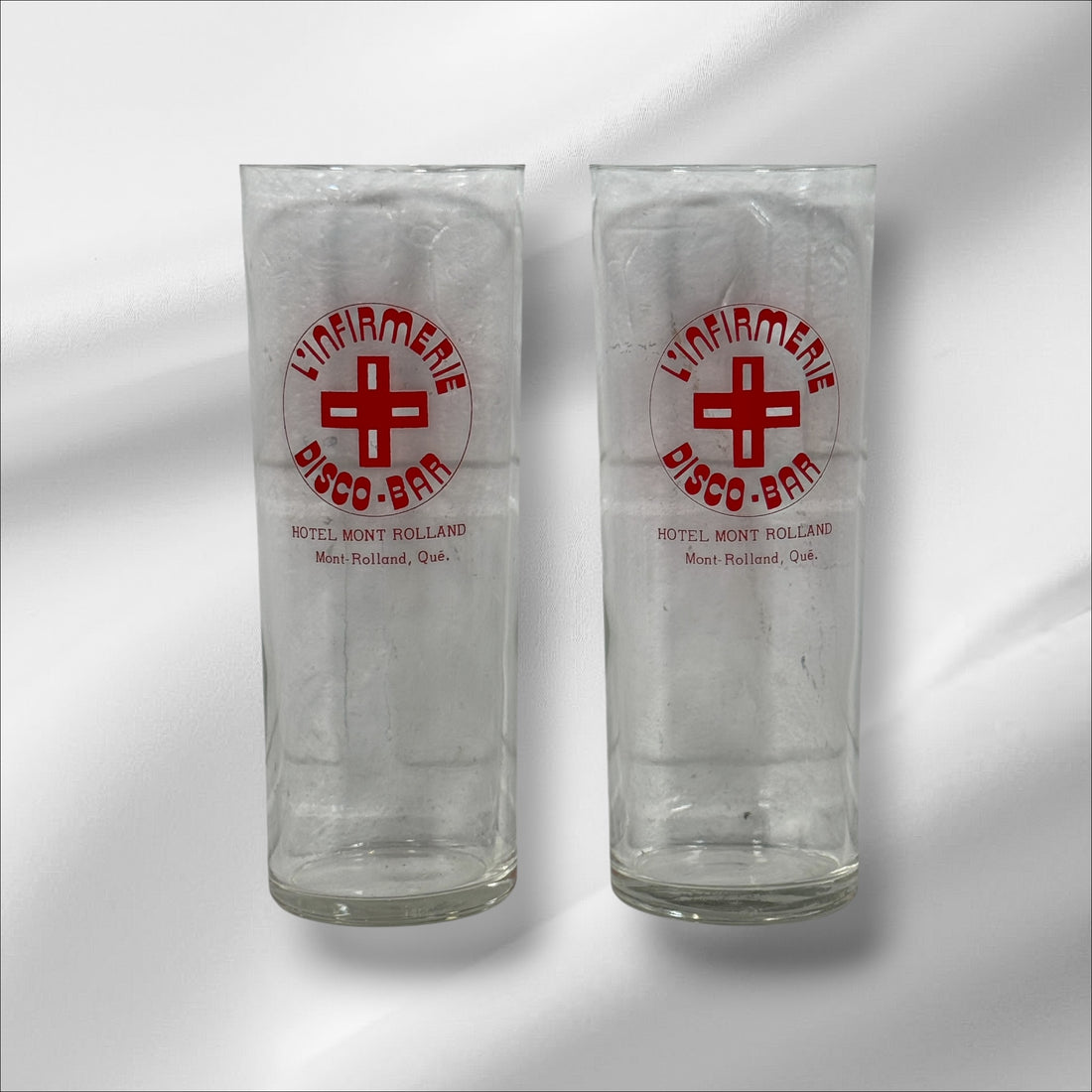 Vintage L’Infirmerie Disco-Bar souvenir glasses from Mont-Rolland, Québec. Rare nightlife memorabilia in excellent condition. Pair of original high-ball glasses.