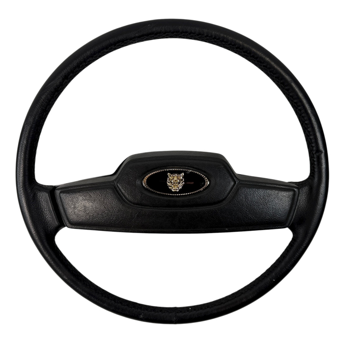 OEM Jaguar XJ6 Series III steering wheel with horn pad. Genuine 1980–87 UK-made replacement part in good driver condition. Vintage Jaguar interior collectible.