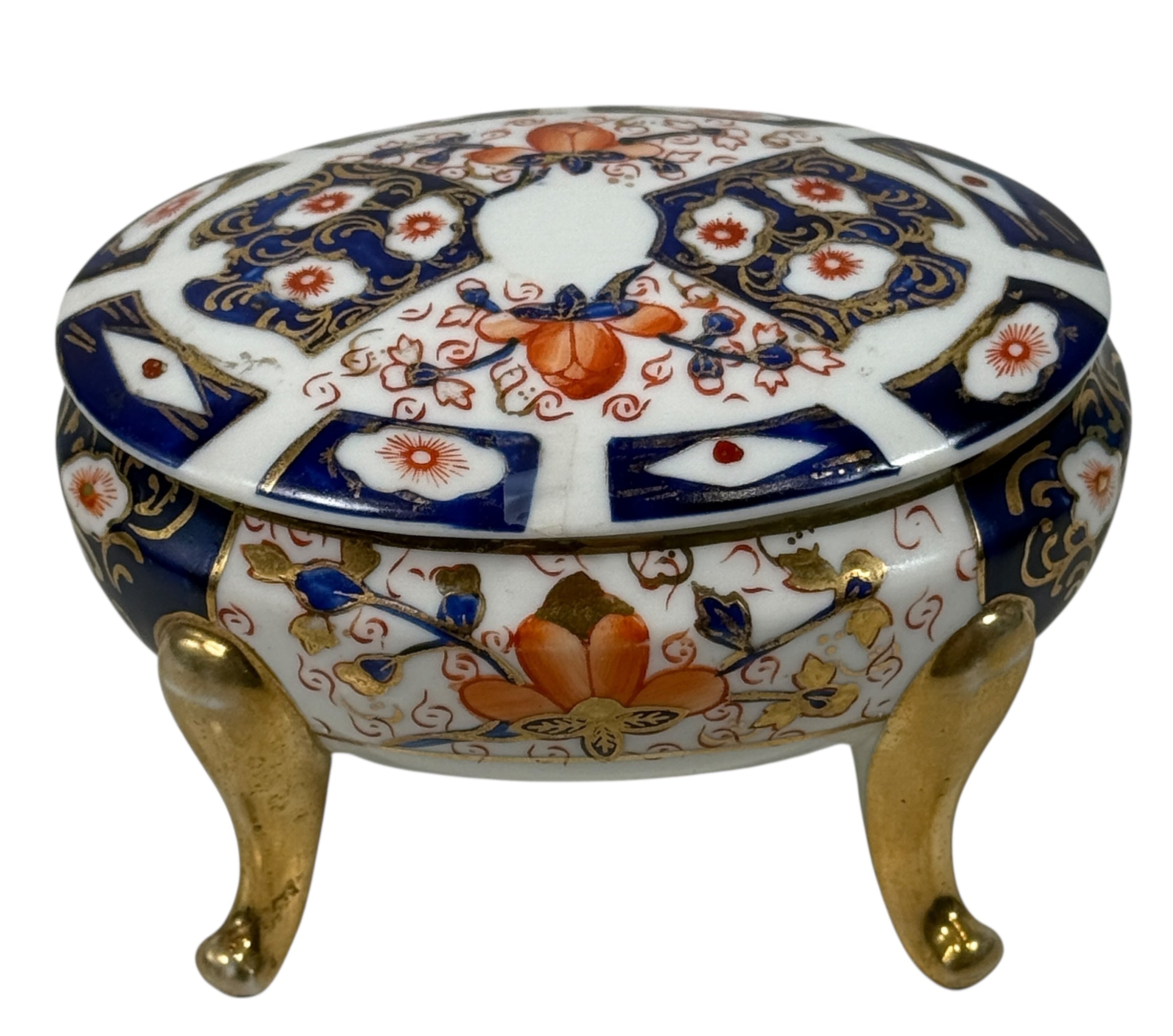 Japanese Imari style porcelain trinket box with lid and brass feet. Decorative vintage export ware in cobalt blue, red, and gilt accents.