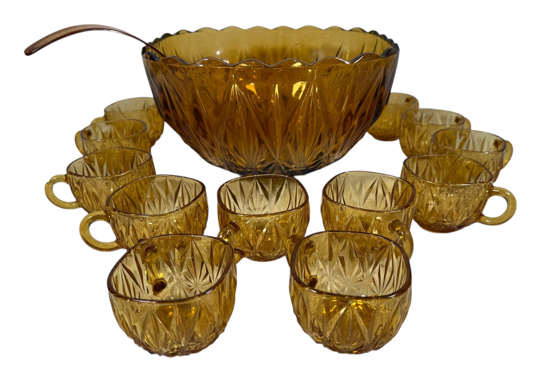 Vintage mid-century amber glass punch bowl set with cups and ladle. Classic starburst pattern, complete set, perfect for retro entertaining.