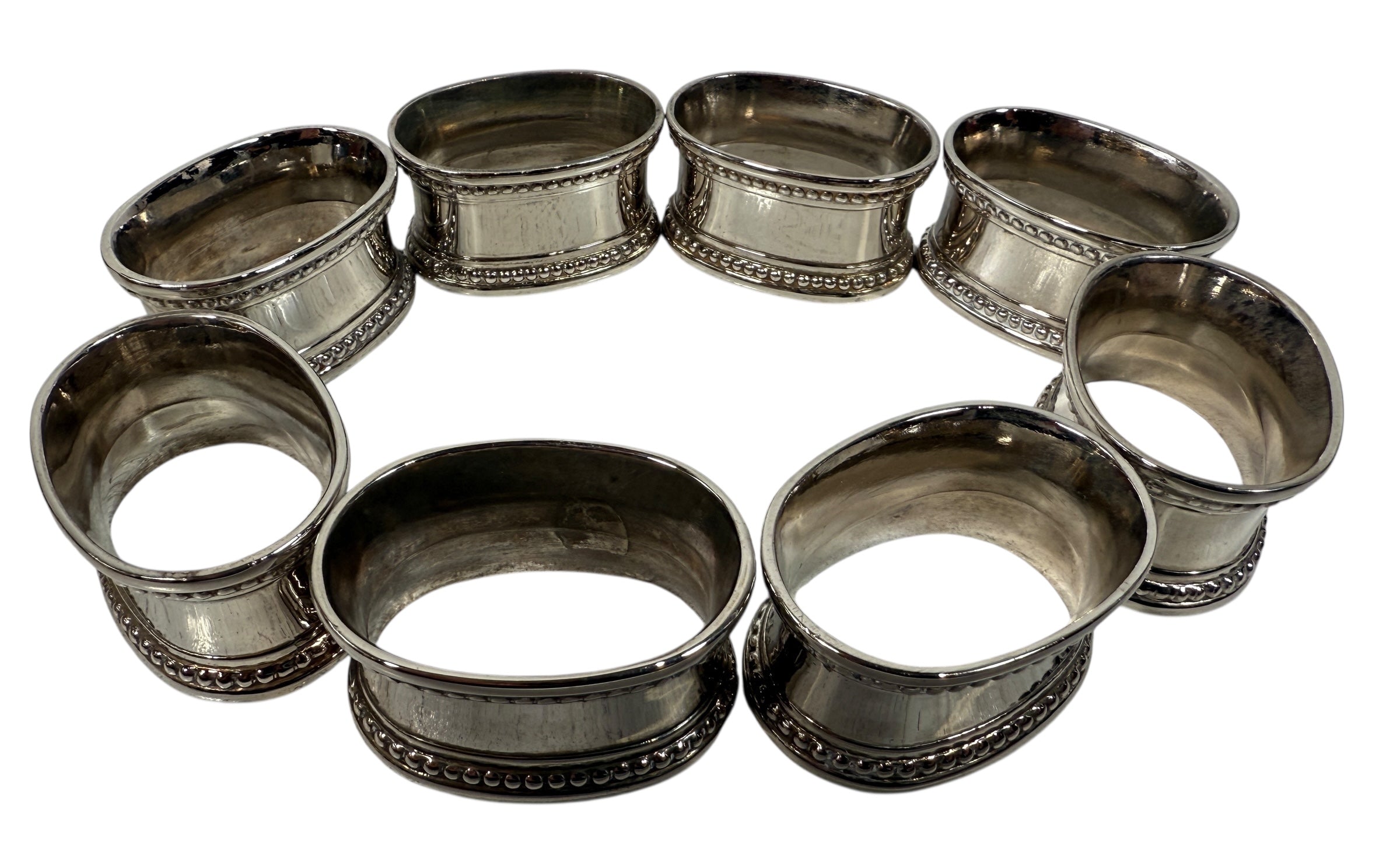 Set of 8 classic silverplate napkin rings with beaded edges. Unmonogrammed, polished, and in very good condition. Timeless tableware.