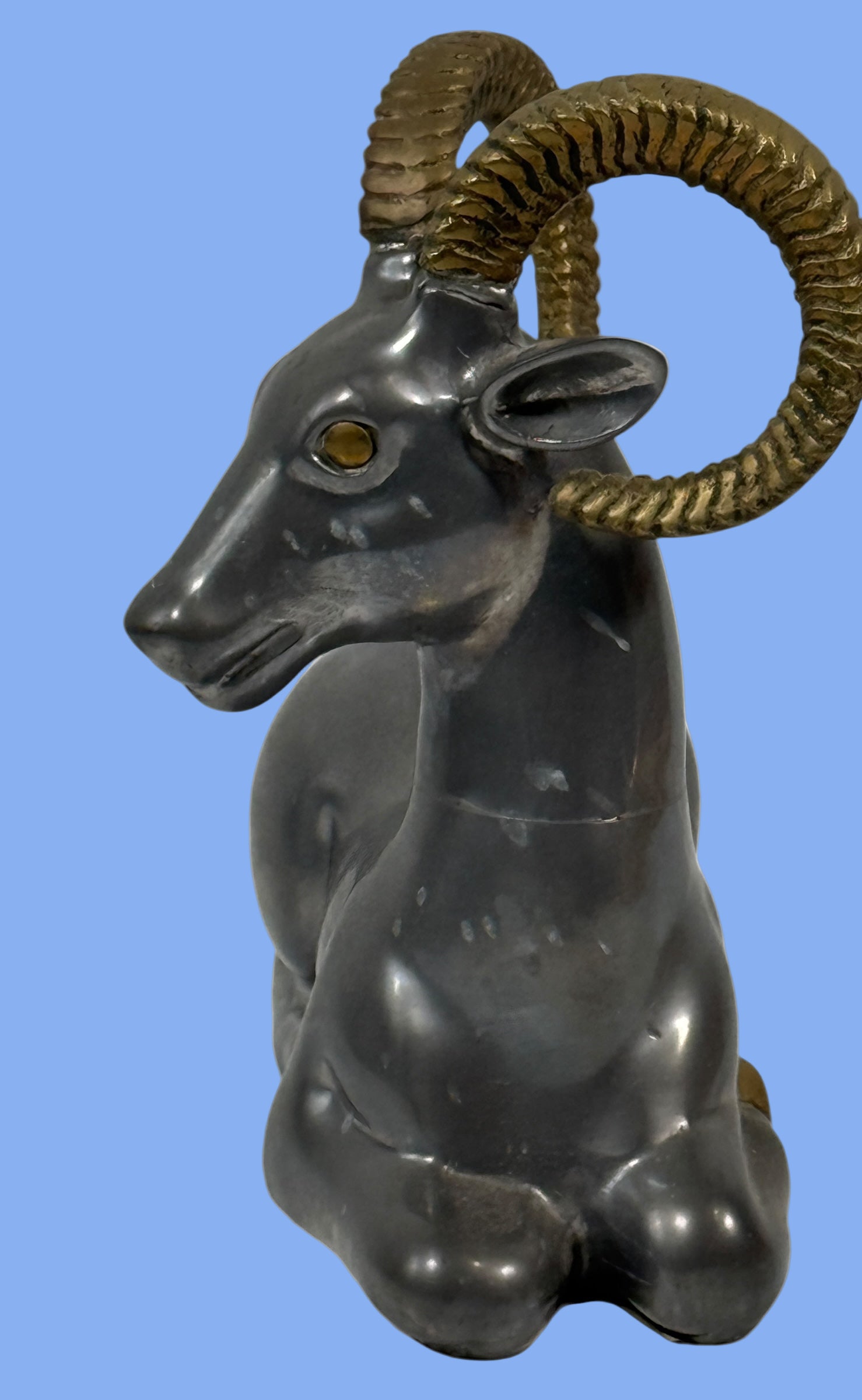 Decorative ram sculpture with gold horns on a white background