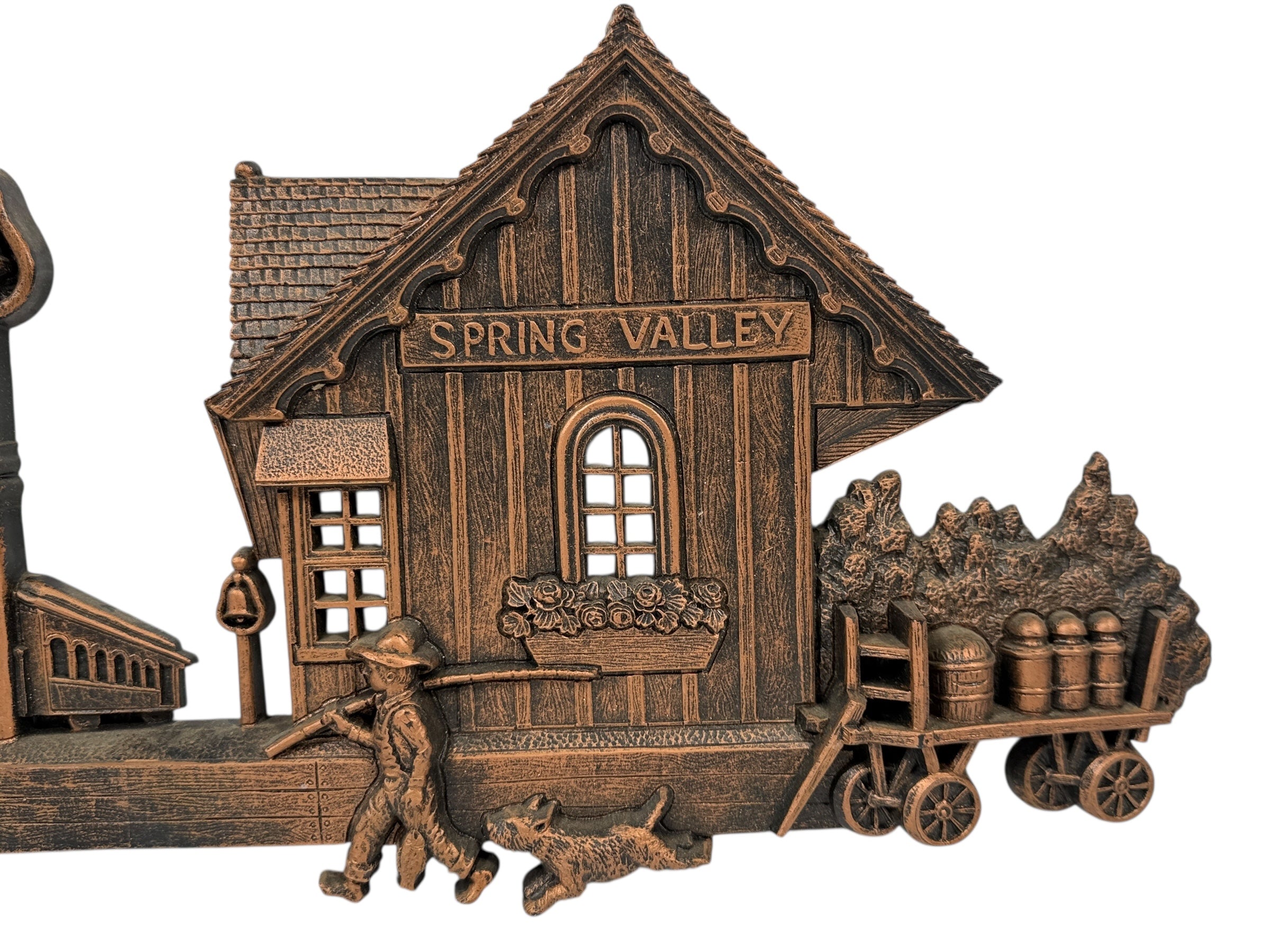 Bronze model of a wooden building with 'Spring Valley' sign, a man with a cart, and a dog.