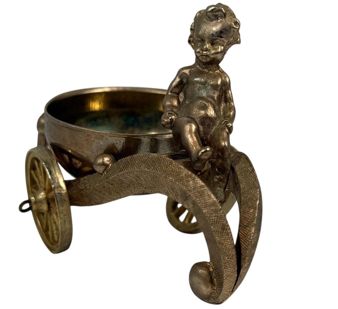 Bronze figurine of a child on a cart with a bowl inside, on a white background