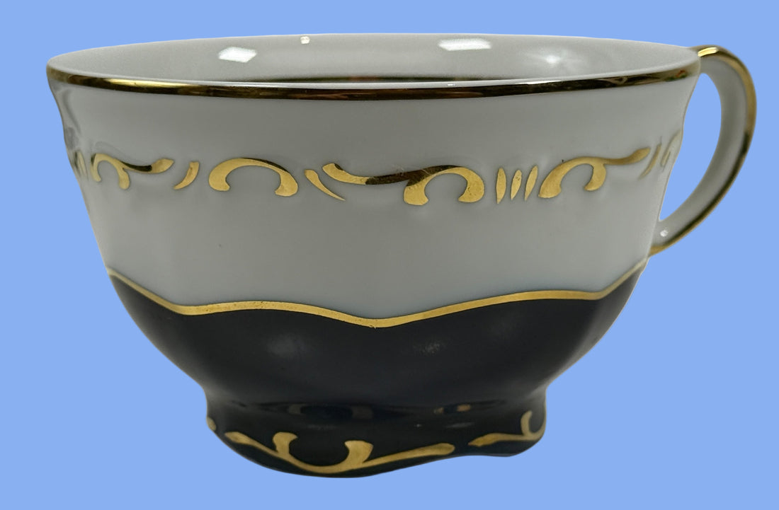 Ceramic teacup with gold decorative elements on a white background