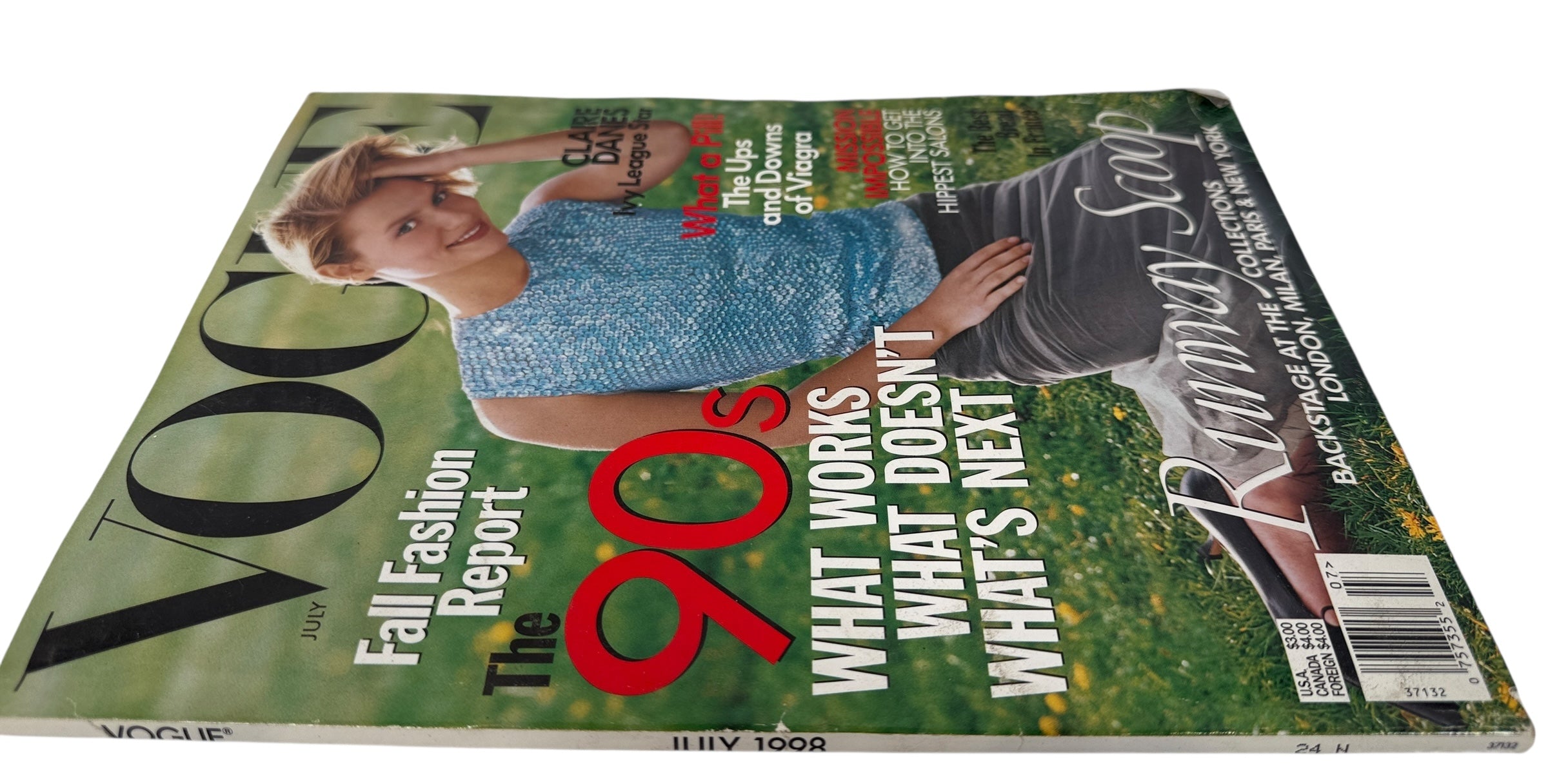 Vogue July 1998  magazine cover featuring a woman in a blue dress with text about fashion and lifestyle topics.