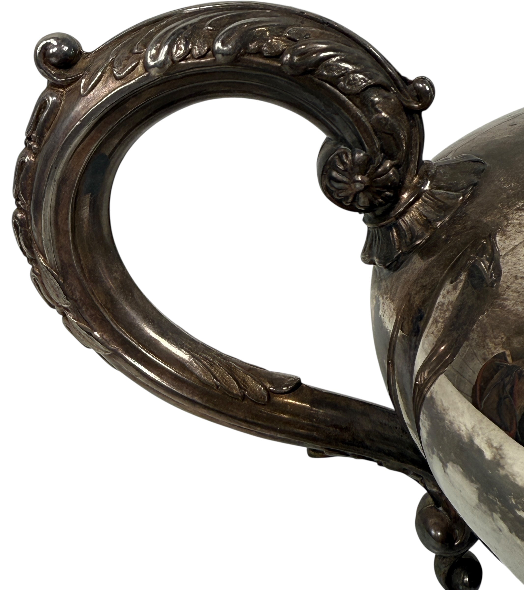 Decorative silver object with intricate designs on a white background