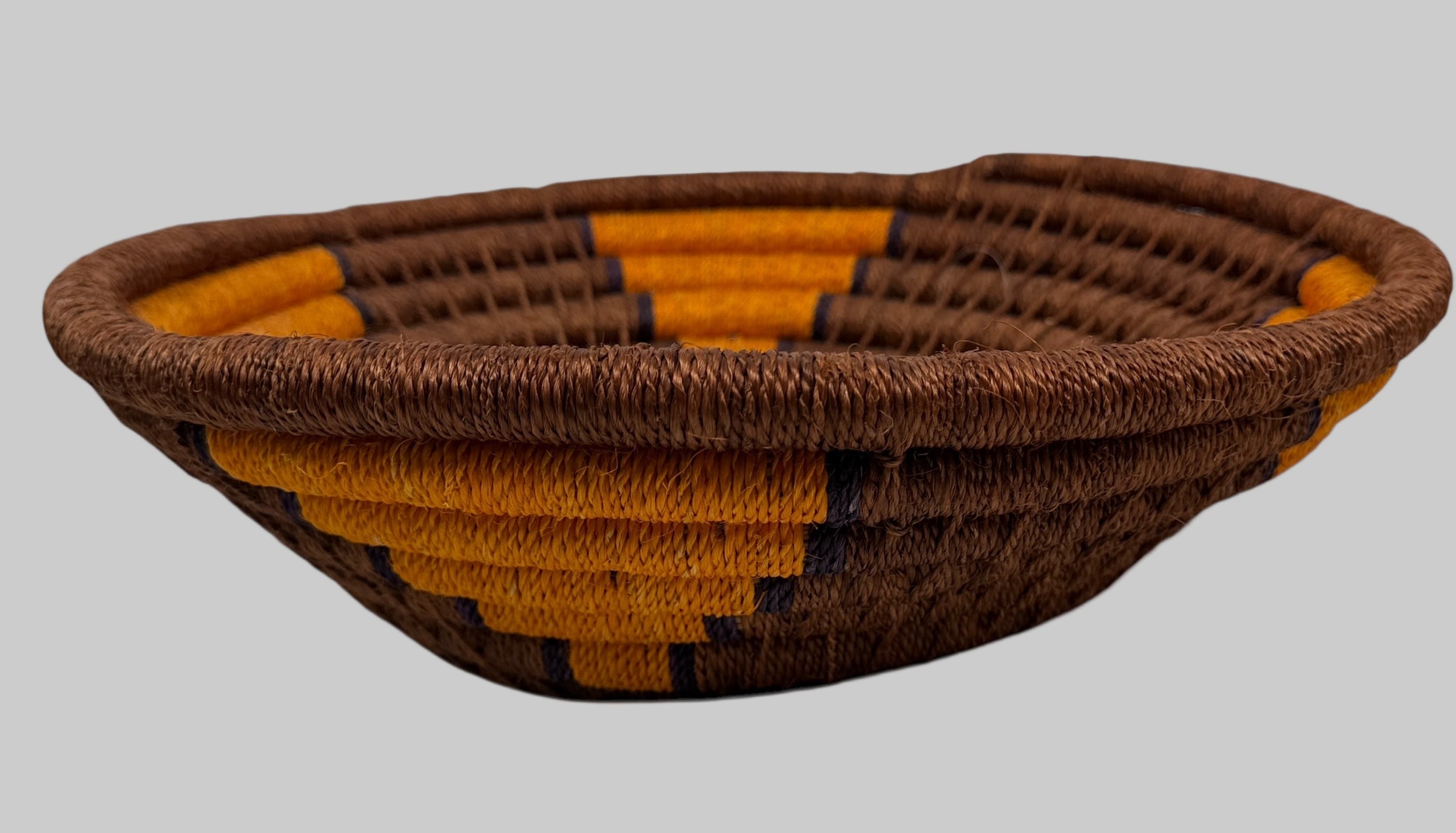 Woven basket with brown and orange pattern on a white background