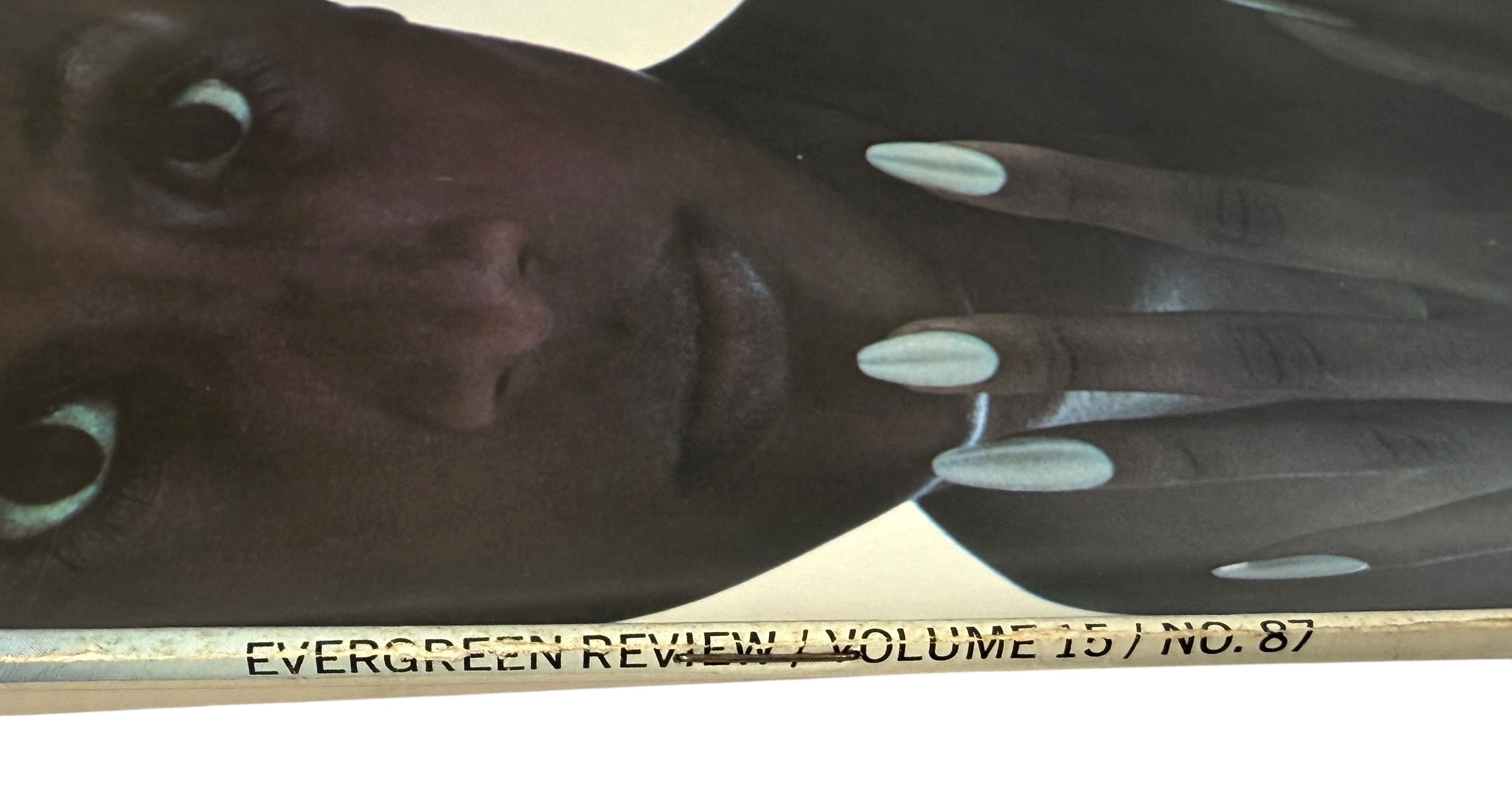 Person with polka dot nails holding a book titled 'Evergreen Review Volume 15 No. 87'.