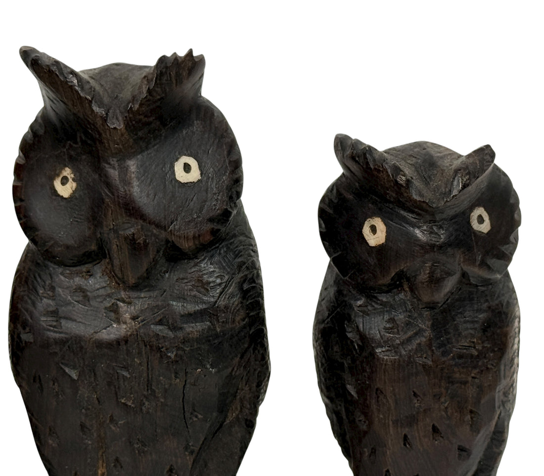 Two wooden owl figurines on a white background