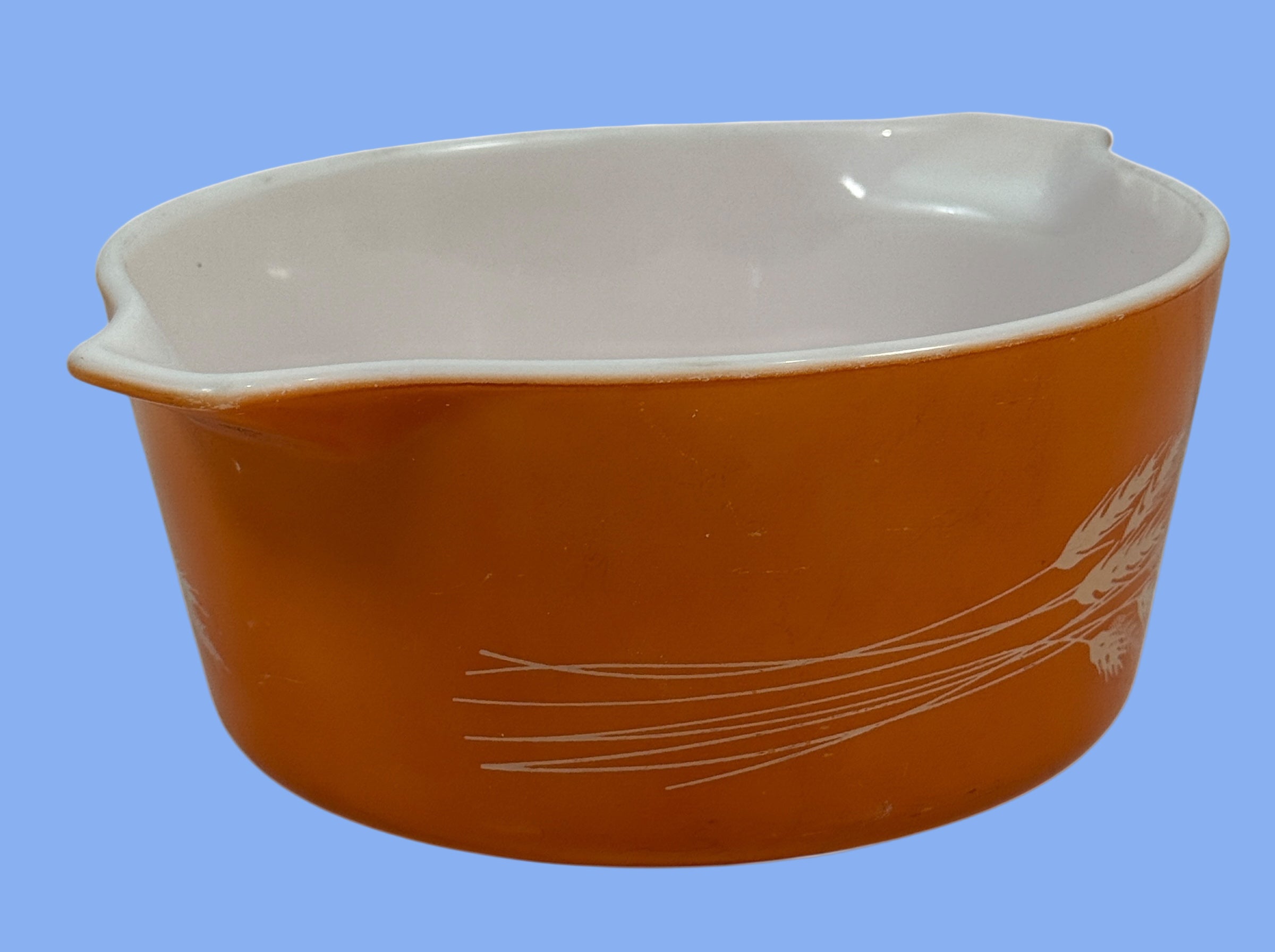 Orange ceramic bowl with white interior on a white background