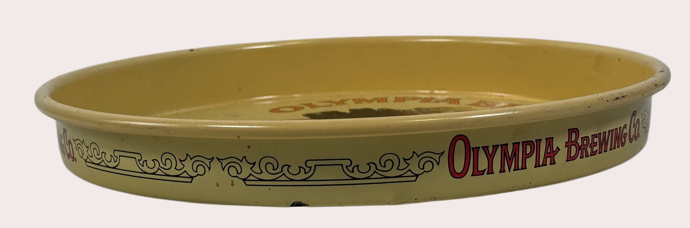 Oval-shaped ceramic dish with 'Olympia Brewing Co.' branding on a beige background