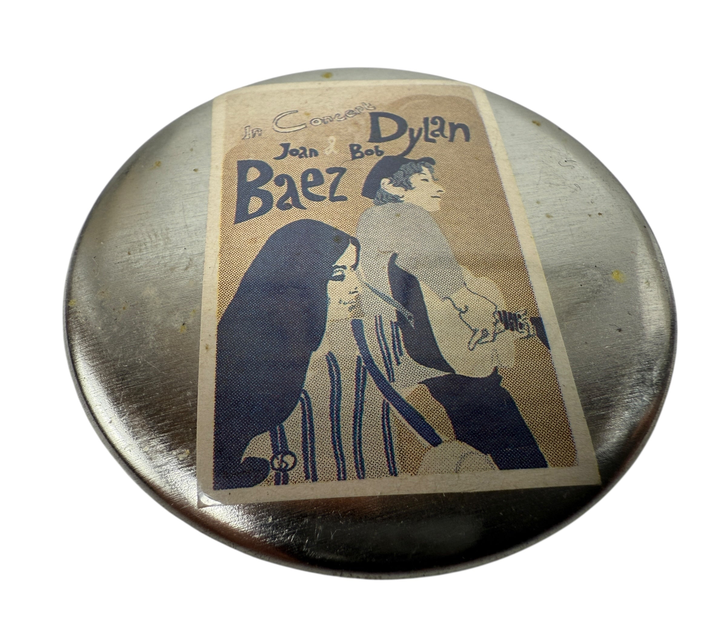 Round metal object with a vintage-style illustration of two people on a white background
