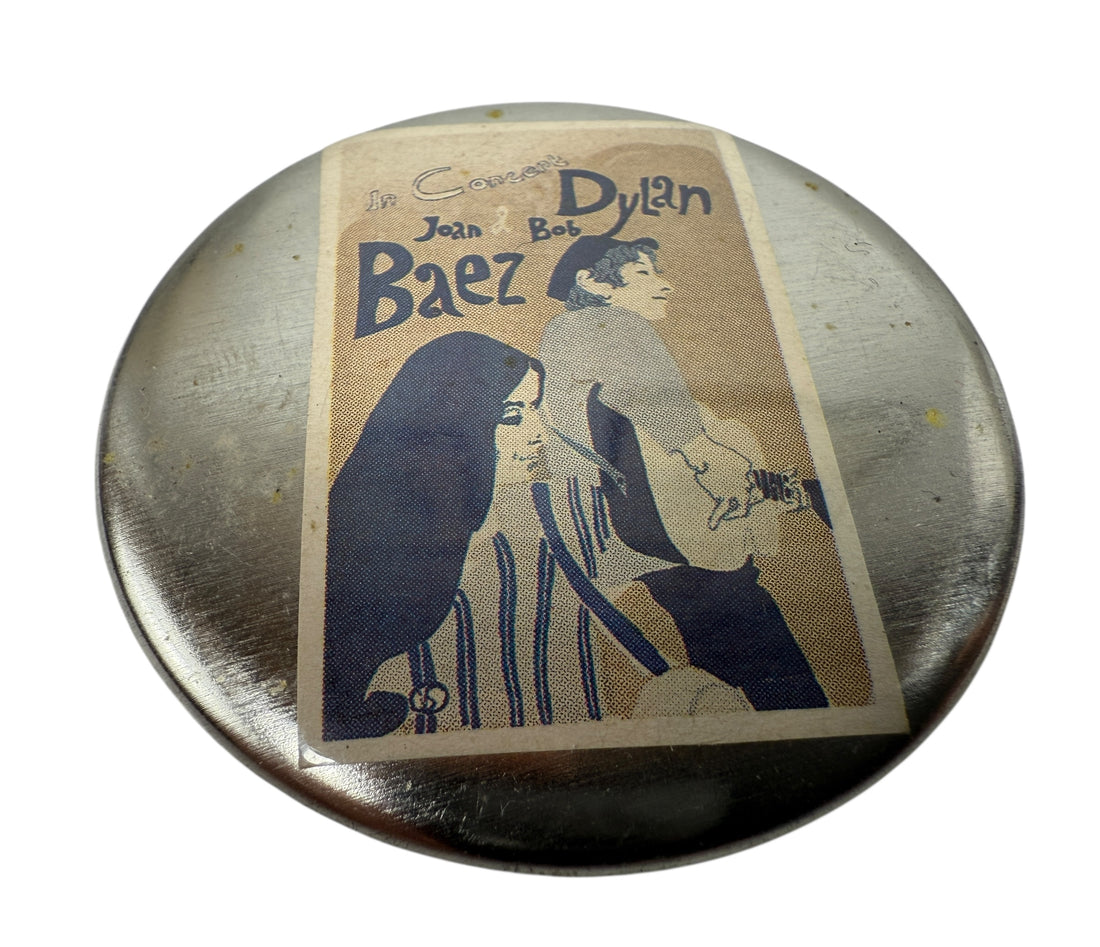 Round metal object with a vintage-style illustration of two people on a white background