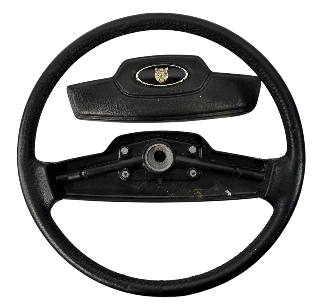 OEM Jaguar XJ6 Series III steering wheel with horn pad. Genuine 1980–87 UK-made replacement part in good driver condition. Vintage Jaguar interior collectible.