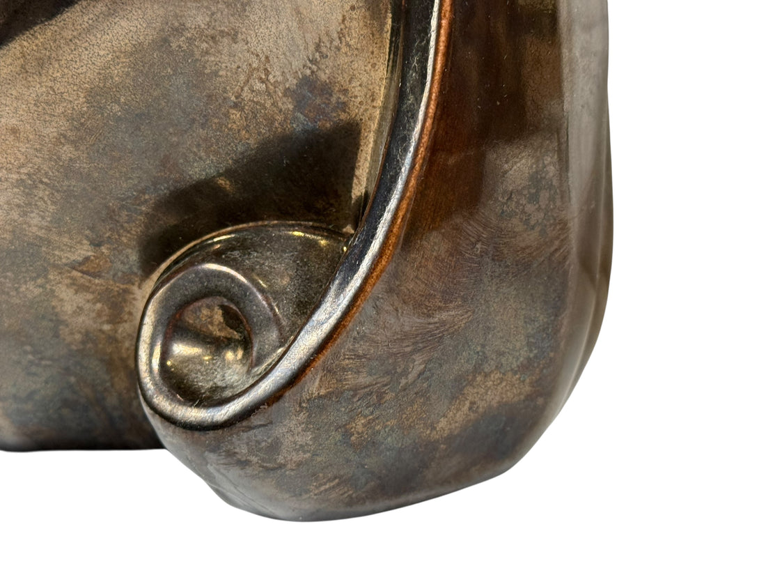 Close-up of a metallic object with a textured surface on a white background