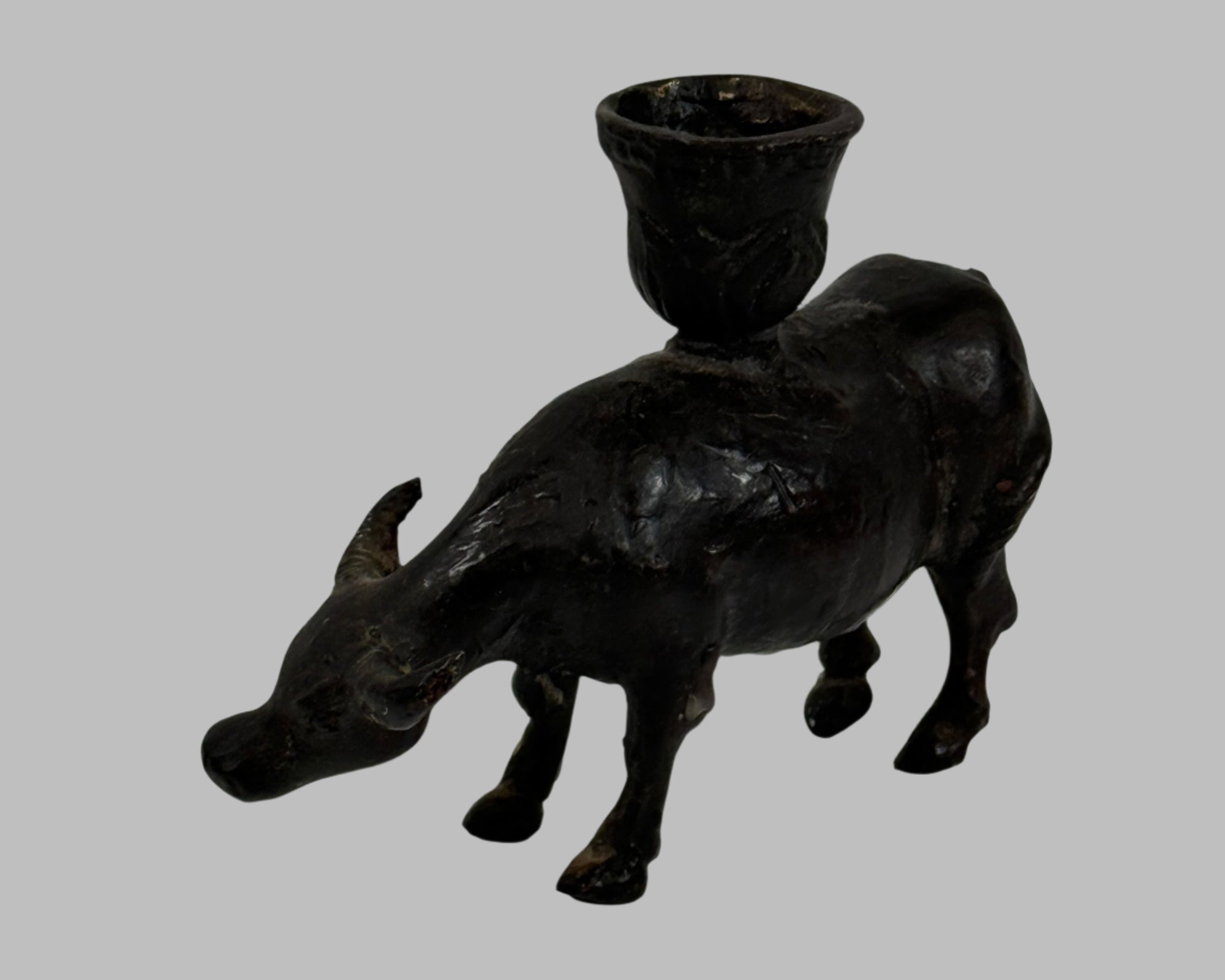 Black metal bull-shaped candle holder on a white background