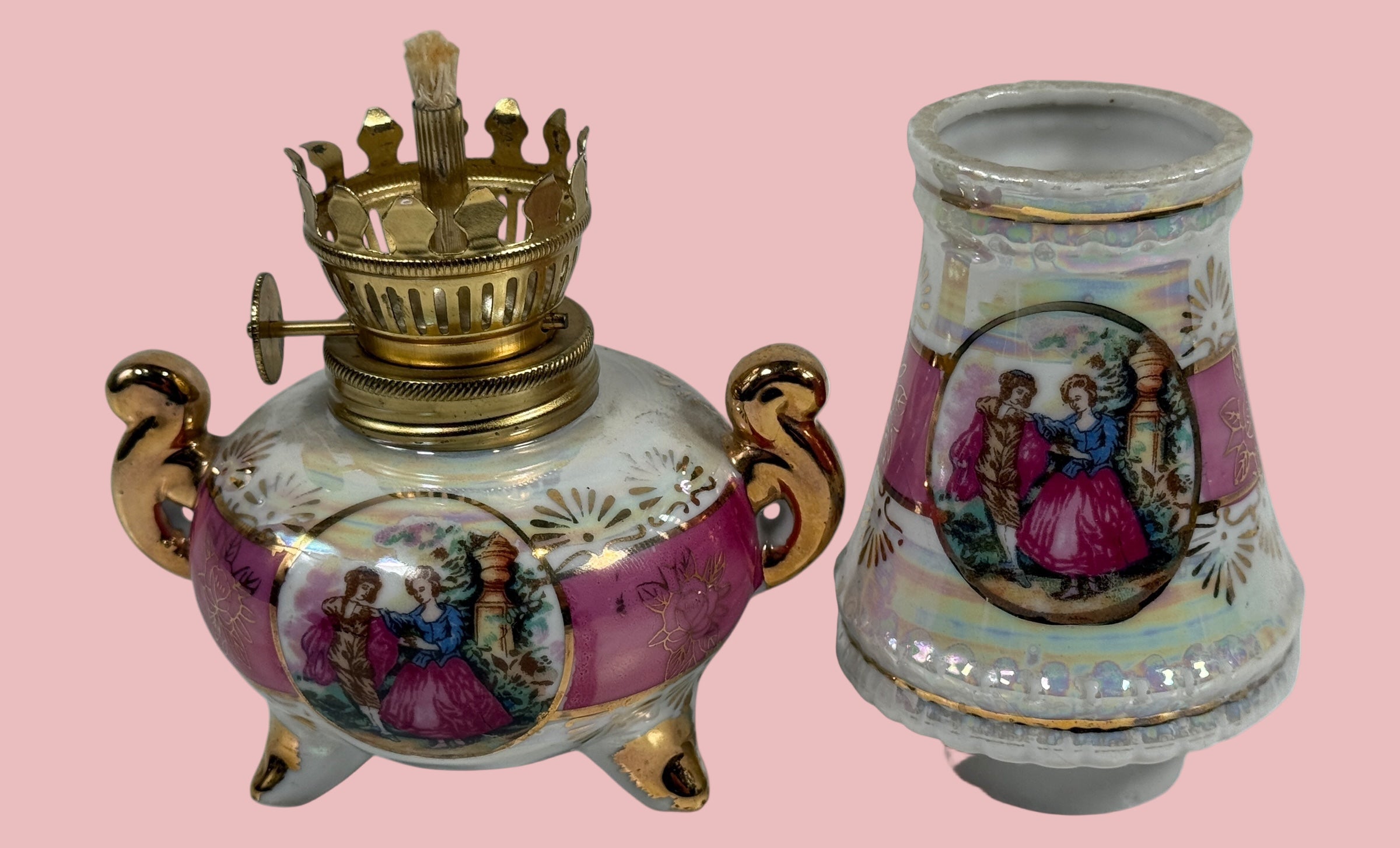 Decorative oil lamp with gold accents and painted scenes on a white background