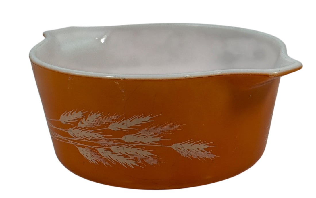 Pyrex, Orange ceramic mixing bowl with white floral design on a white background