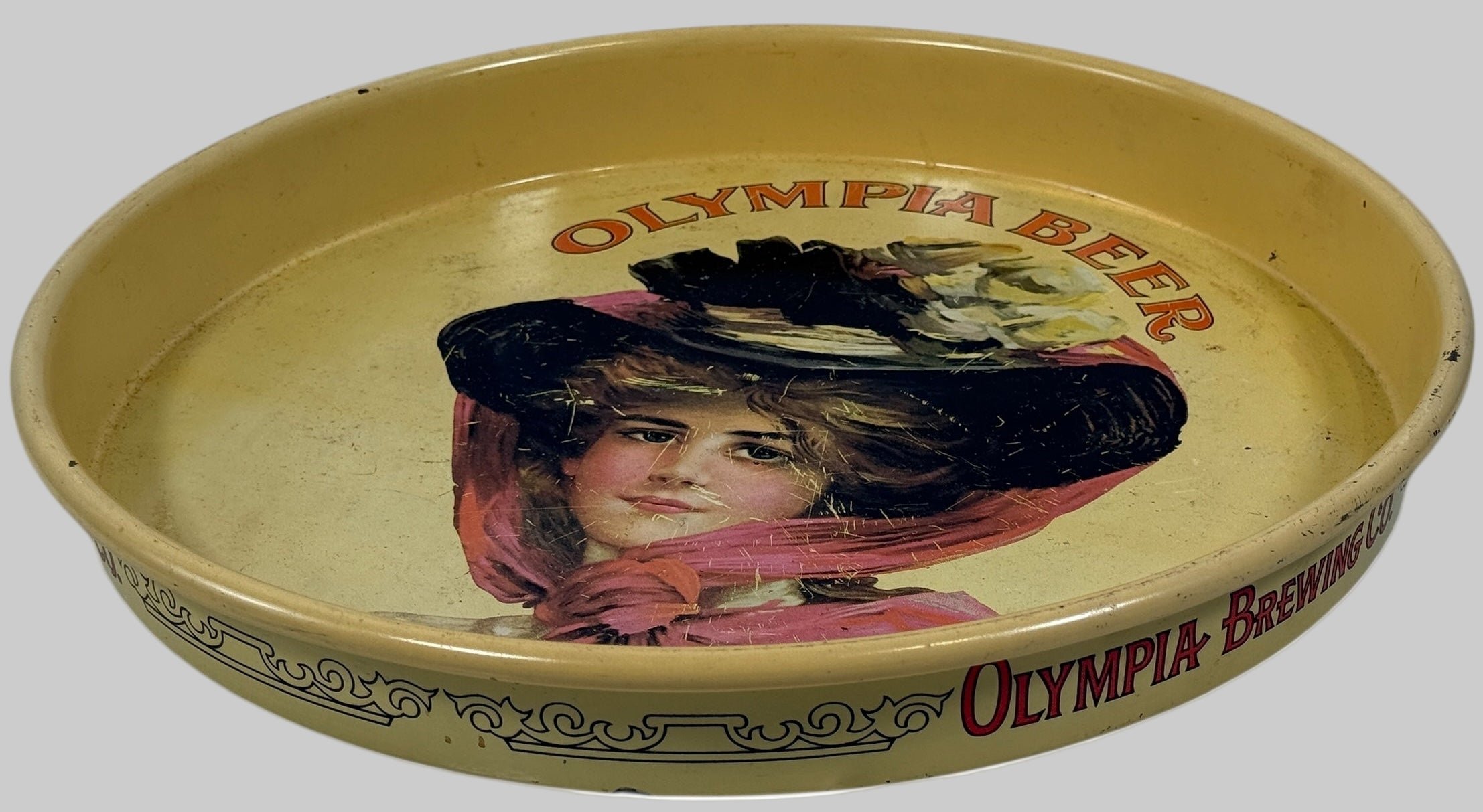 Vintage Olympia Beer tray with a woman's portrait and branding.
