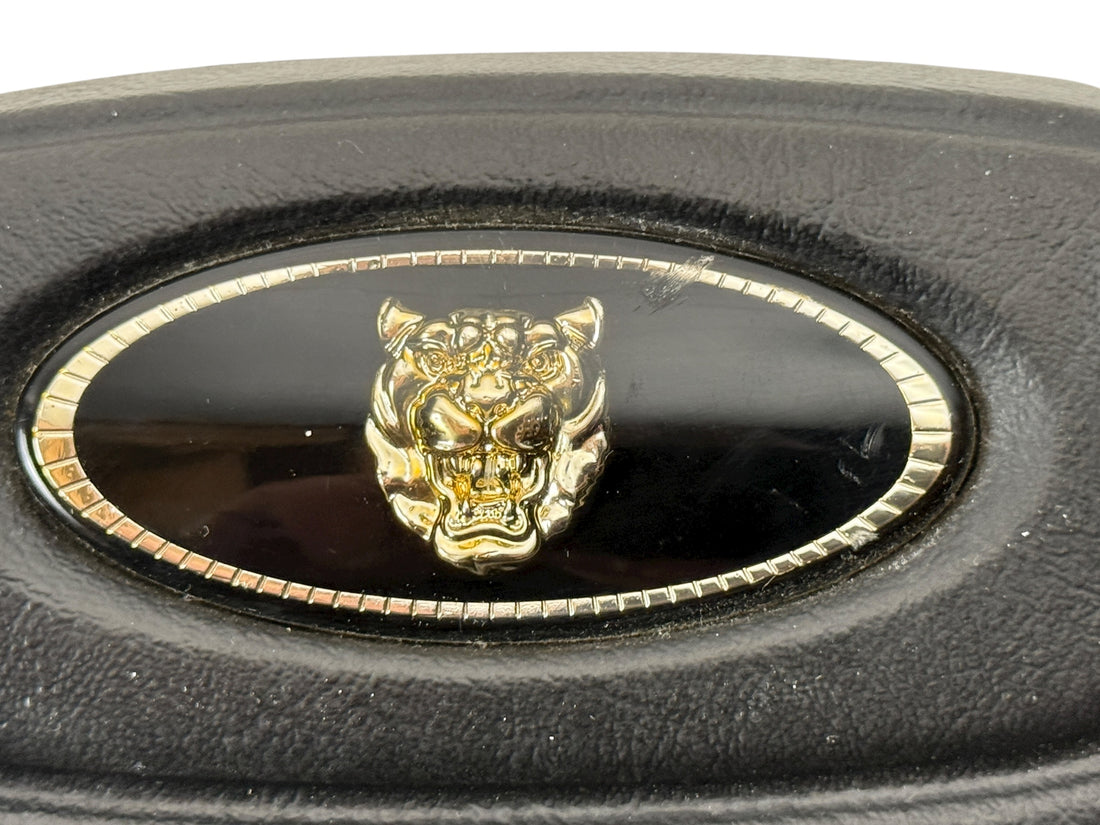 OEM Jaguar XJ6 Series III steering wheel with horn pad. Genuine 1980–87 UK-made replacement part in good driver condition. Vintage Jaguar interior collectible.