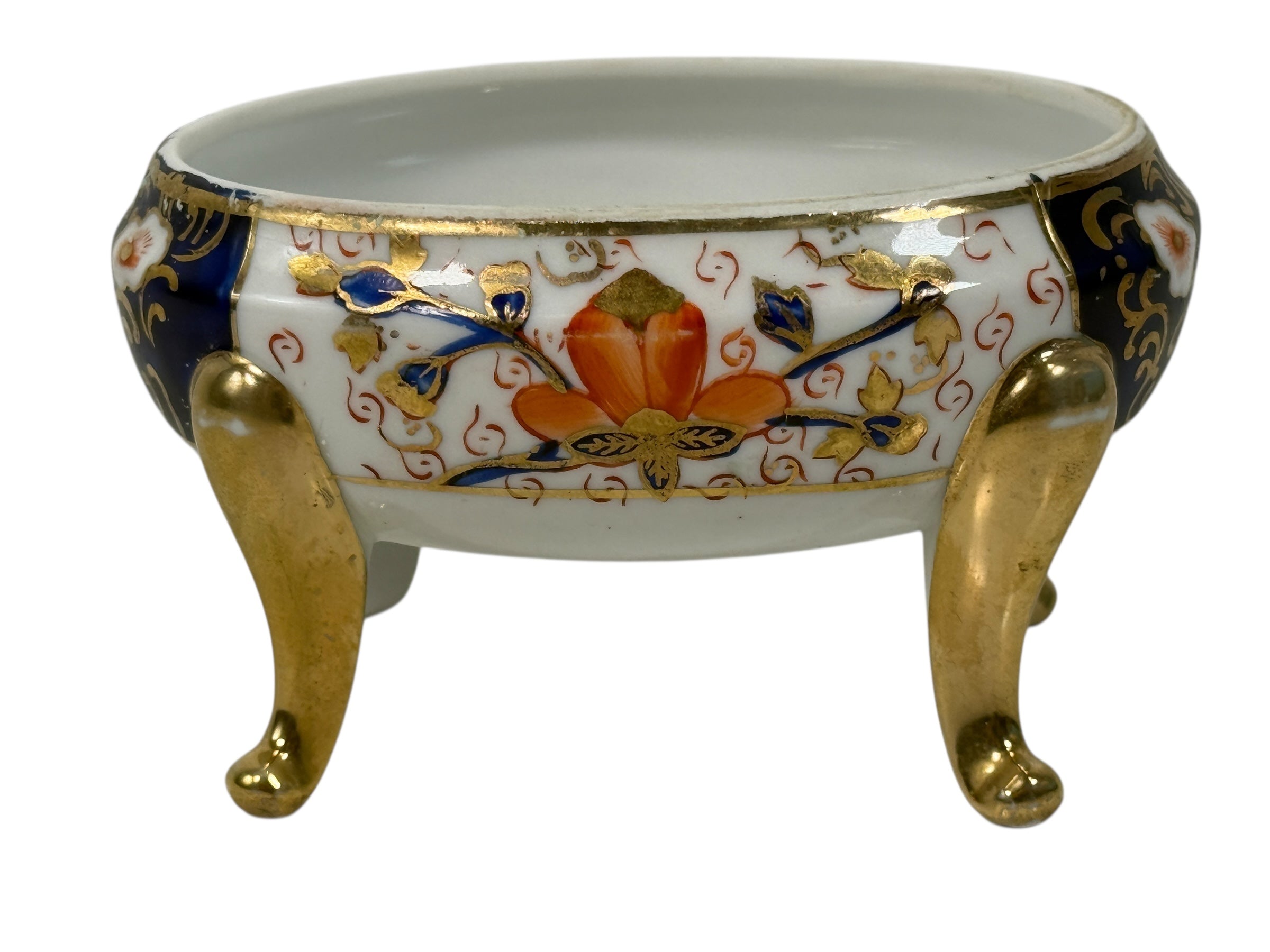 Japanese Imari style porcelain trinket box with lid and brass feet. Decorative vintage export ware in cobalt blue, red, and gilt accents.