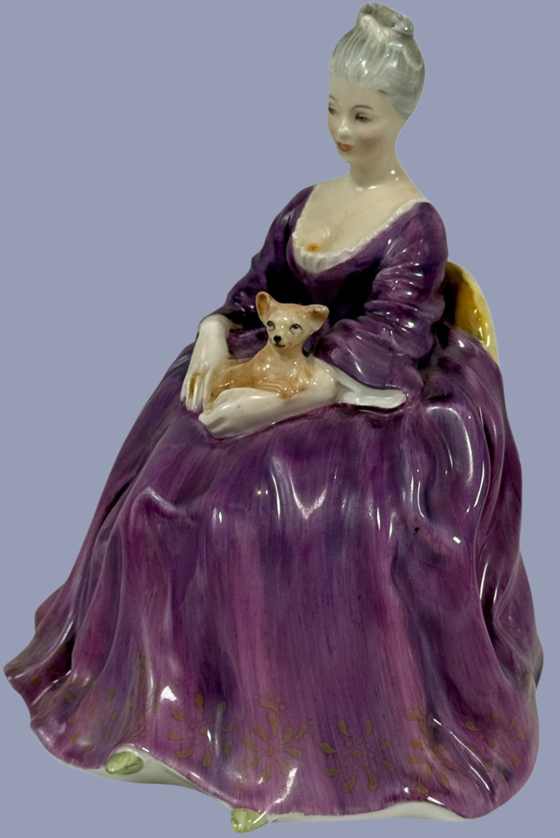 Porcelain figurine of a woman in a purple gown holding a dog on a white background