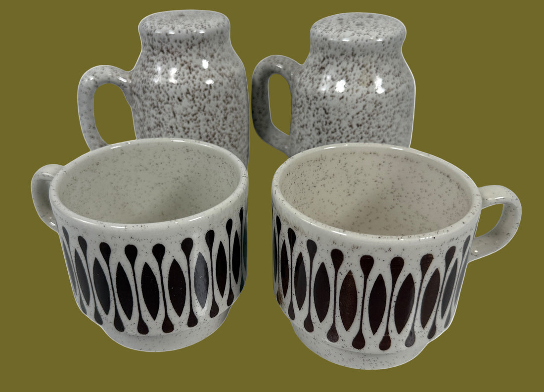 Set of ceramic mugs with speckled gray finish and black pattern on a white background