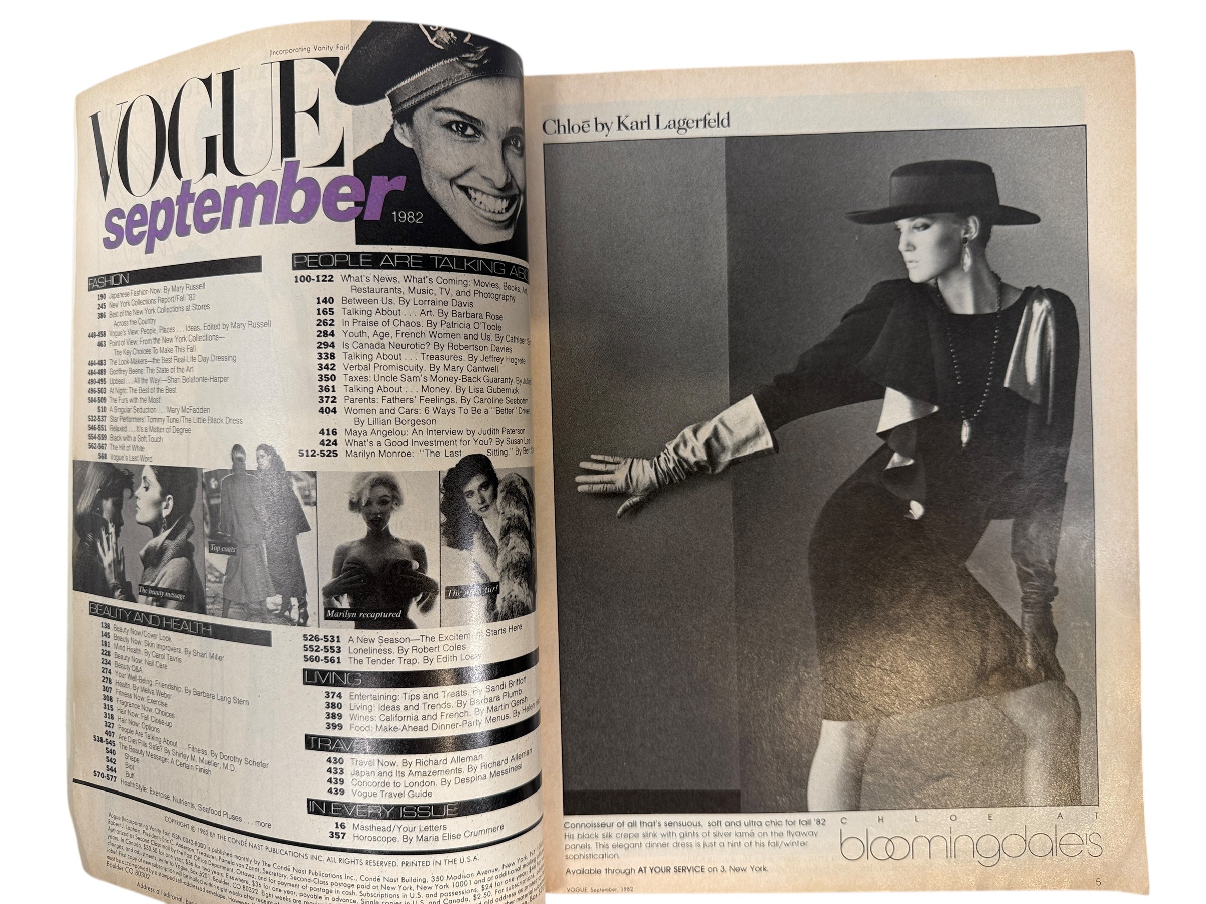 Open magazine with fashion spread featuring a model in a hat and dress, labeled 'Vogue September 1983'.