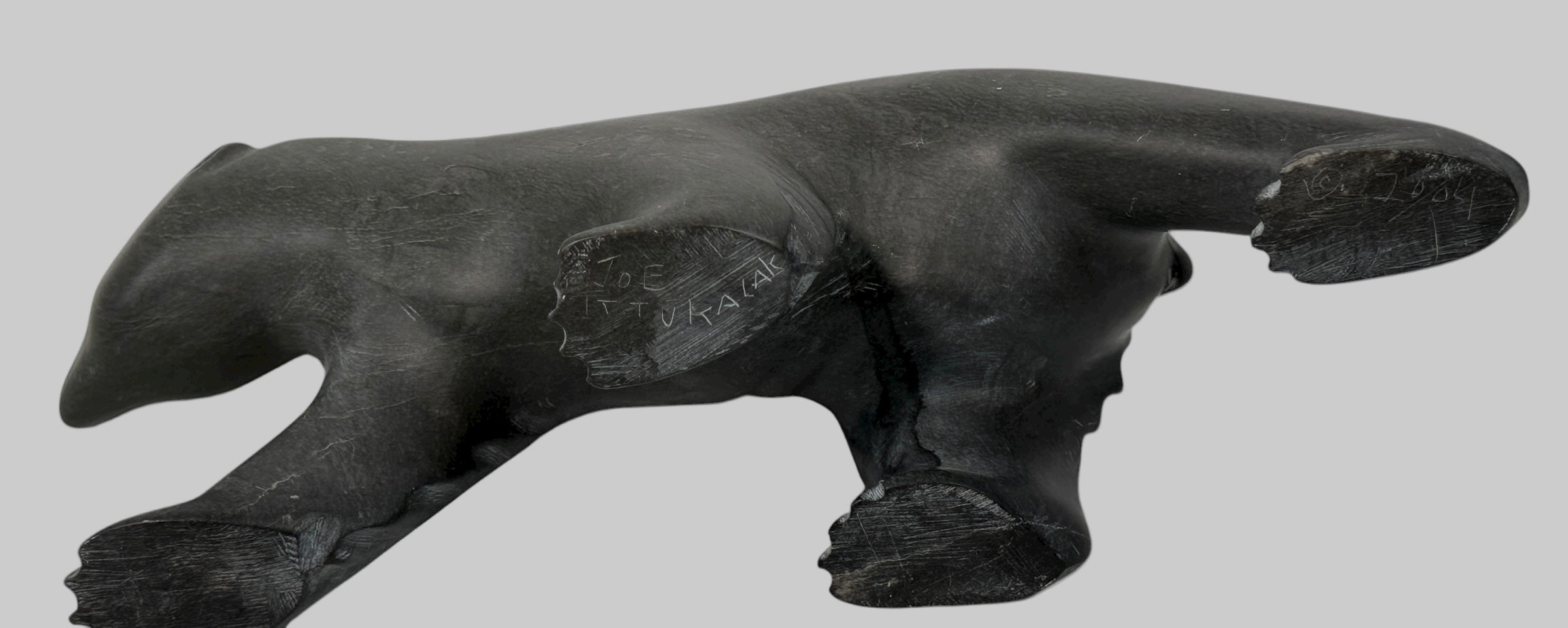 Signed Inuit soapstone bear by Joe Ittukalak (2004) from Nunavik. 10-inch Canadian carving in dark stone—authentic Indigenous art sculpture.